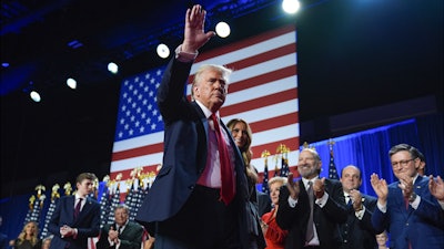 Republican presidential nominee former President Donald Trump waves as he walks with former first lady Melania Trump at an election night watch party at the Palm Beach Convention Center, Wednesday, Nov. 6, 2024, in West Palm Beach, Fla.