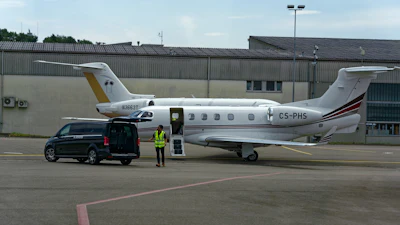 Parked private jets with worker at Zürich Kloten Airport in Switzerland.