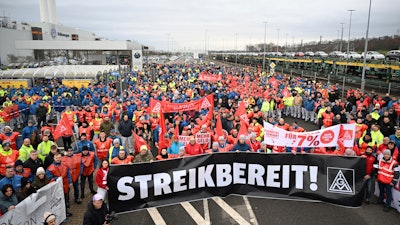 Volkswagen workers march holding a sign with writing reading in German 'Ready to Strike!' on the first day of a nationwide warning Volkswagen workers' strike, in Zwickau, Germany, Monday, Dec. 2, 2024.