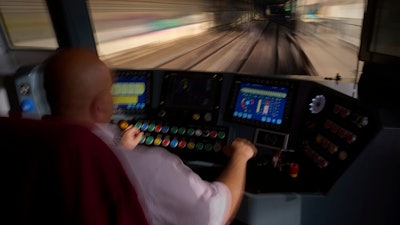 A subway driver operates the train's brake lever before entering a station in Barcelona, Spain, Monday, Dec. 2, 2024.