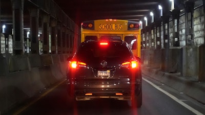 PiggyBack Network co-founder and CEO Ismael El-Amin drives his car behind a Chicago Public Schools bus as on this day he will take three children, including one of his own, to various schools as part of the PiggyBack ride-share network Thursday, Oct. 10, 2024, in Chicago.