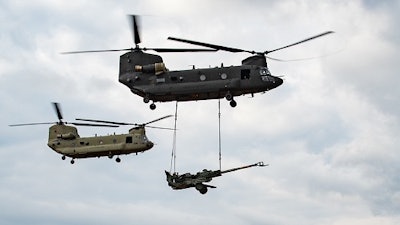 A U.S. Army CH-47F Block II Chinook conducts a sling load test alongside a CH-47F Block I aircraft.