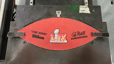 A part of a football for the upcoming Super Bowl matchup between the Philadelphia Eagles and the Kansas City Chiefs sits on a machine at the Wilson Sporting Goods football factory, Monday, January 27, 2025, in Ada, Ohio.
