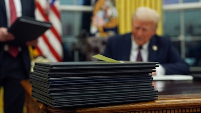 President Donald Trump signs executive orders in the Oval Office of the White House, Jan. 20, 2025, in Washington.