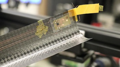 The extended boom showing a lightweight, flexible electronics patch with a motion sensor, and a temperature sensor mounted on the boom tip.