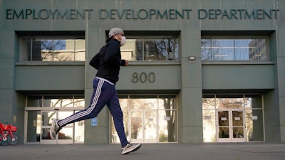 In this Dec. 18, 2020, file photo a runner passes the office of the California Employment Development Department in Sacramento, Calif.