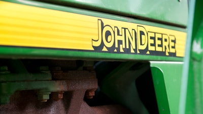 The John Deere logo on the side of a tractor.