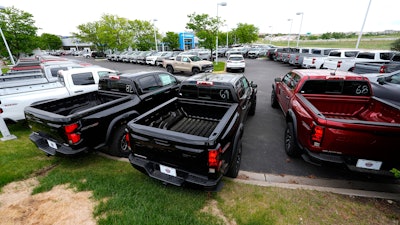 Unsold 2024 Colorado and Silverado pickup trucks sit in rows outside a Chevrolet dealership Sunday, June 2, 2024, in Lone Tree, Colo.