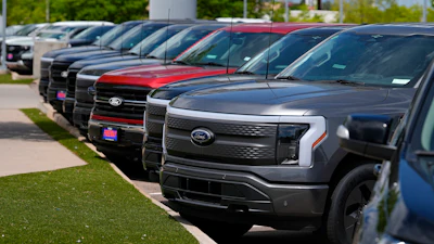 A line of unsold 2024 F150 and Lightning electric pickup trucks sit at a Ford dealership Sunday, May 19, 2024, in Denver.
