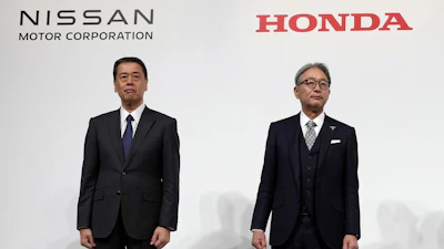 Nissan Chief Executive Makoto Uchida, left, Honda Chief Executive Toshihiro Mibe, right, with Takao Kato, CEO of Mitsubishi Motors, not in photo, pose for photographers during a joint news conference in Tokyo, Japan, on Dec. 23, 2024.