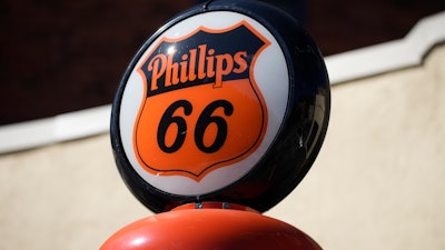 The logo for Phillips 66 gasoline is shown on a sign topping an old gasoline pump on display outside a store, May 25, 2021, in the gambling hot spot of Deadwood, S.D.