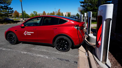 A Tesla Model 3 charges at a Tesla supercharging station situated in the parking lot of an outlet mall on Sept. 25, 2024, in Lakewood, Colo.