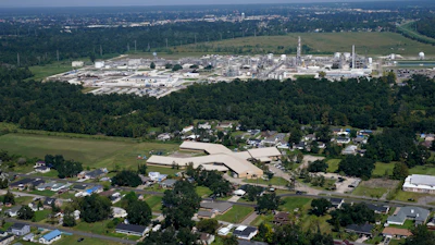 The Fifth Ward Elementary School and residential neighborhoods sit near the Denka Performance Elastomer Plant, back, in Reserve, La., Sept. 23, 2022.