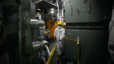 A worker in hazmat suit walks at the area under the Unit 5 reactor pressure vessel, which survived the earthquake-triggered tsunami in 2011, at the Fukushima Daiichi nuclear power plant, run by Tokyo Electric Power Company Holdings (TEPCO), in Futaba town, northeastern Japan, on Monday Feb. 20, 2025.