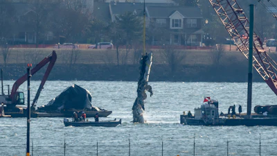 A piece of wreckage is lifted from the water onto a salvage vessel near the site in the Potomac River of a mid-air collision between an American Airlines jet and a Black Hawk helicopter, at Ronald Reagan Washington National Airport, Feb. 4, 2025, in Arlington, Va.