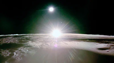 This image provided by NASA/Firefly Aerospace, Tuesday, March 18, 2025, shows the sun setting on the moon, with Earth and Venus in the distance.