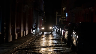 Headlights illuminate cobblestone streets in Old San Juan, Puerto Rico, during an island-wide blackout, Wednesday, April 16, 2025.
