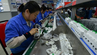 Workers assemble circuit breakers at a manufacturer of electronic equipment, in Fuyang city in central China's Anhui province on April 15, 2025.