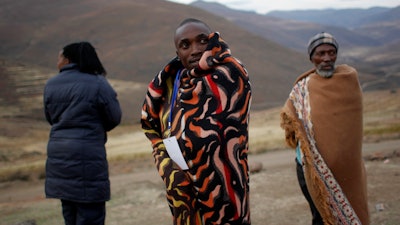 A Lesotho election official makes a phone call as he waits for last minute voters near the eastern Lesotho town of Mokhotlong Saturday May 26, 2012.