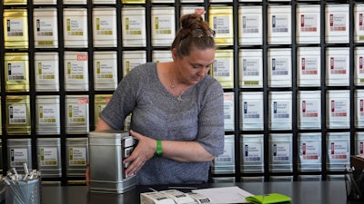 Owner Lisa McDonald packages a loose leaf tea orders at the TeaHaus, April 24, 2025, Ann Arbor, Mich.