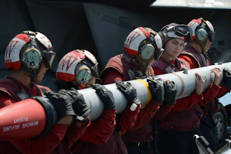 In this handout photo from the U.S. Navy, sailors load an AIM-120C missile into an F/A-18E Super Hornet aboard the aircraft carrier USS Nimitz in the Persian Gulf on Aug. 8, 2017.