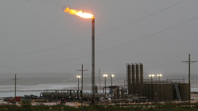 Strong winds kick up dust as a facility in the Permian Basin flares natural gas east of Carlsbad, N.M., on Monday, May 19, 2025.