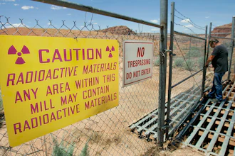 U.S. Energy Corp. resident project manager Daryl Winters locks the gate, on July 12, 2006, at the Shootaring Mill north of Ticaboo, Utah.