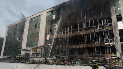 Rescue workers put out a fire of a building damaged by a Russian drone strike on Kyiv, Ukraine, Tuesday, June 10, 2025.