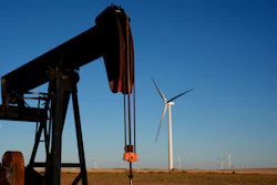 Pumpjacks operate in the foreground while a wind turbines at the Buckeye Wind Energy wind farm rise in the distance Monday, Sept. 30, 2024, near Hays, Kan.