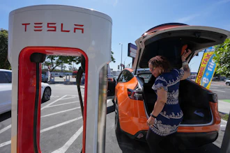 Janelle Lowe prepares to charge her electric vehicle at a station May 22, 2025, in Long Beach, Calif.