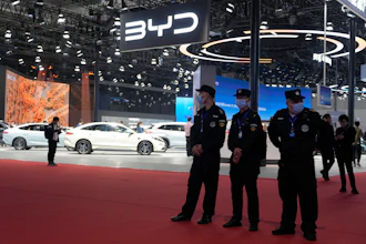 Security personnel on duty stand near the BYD booth during the Shanghai auto show, April 23, 2025.