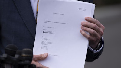 Energy Secretary Chris Wright holds a report concerning U.S. exports of liquefied natural gas (LNG) as he speaks to reporters at the White House in Washington, on March 19, 2025.