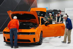 Shoppers look over a 2025 Dodge Charger Daytona hardtop in the Stellantis display at the Colorado Auto Show, April 17, 2025, in Denver.