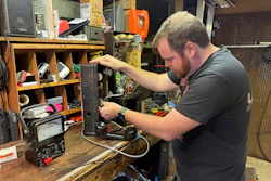 Patrick Schlott repairs an old pay phone in his basement workshop on July 16, 2025, in Williamstown, Vt.