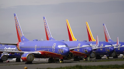 A line of Southwest Air Boeing 737 jets are parked near the company's production plant while being stored at Paine Field Friday, April 23, 2021, in Everett, Wash.