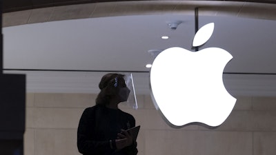 An Apple store employee stands inside the store in New York on Feb. 5, 2021.