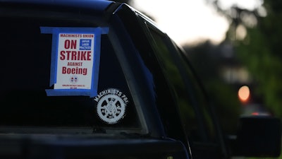 A truck displays a small strike sign in the parking lot of the Aerospace Machinists Union hall as Boeing employees arrive to vote on a new contract offer from the company, Nov. 4, 2024, in Renton, Wash.