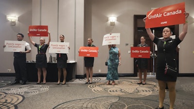 Air Canada executives leave after they are interrupted by Air Canada flight attendants during a press conference as a possible strike looms, in Toronto, on Thursday, Aug. 14, 2025.