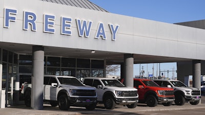 A long line of unsold 2024 pickup trucks sit on display at Ford dealership Thursday, Nov. 28, 2024, in southeast Denver.