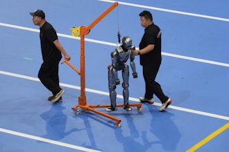 Workers transfer a robot before the opening ceremony for the World Humanoid Robot Games held in Beijing, China, Thursday, Aug. 14, 2025.