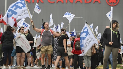 People protest outside Air Canada headquarters in Montreal, Sunday, Aug. 17, 2025, after the federal government is intervened in the labour dispute between the airline and the union representing its flight attendants, ordering binding arbitration and operations to resume.