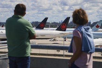 Travelers look out over grounded Air Canada planes as flight attendants picket at Pearson International Airport in Toronto, Monday, Aug. 18, 2025.