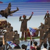 A human performer leaps above robots dressed like terracotta warriors during the opening ceremony of The World Humanoid Robot Games held in Beijing, China, Thursday, Aug. 14, 2025.