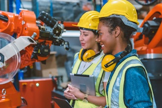 Technicians examine robotic machinery.