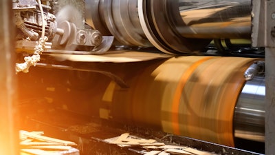 Ready-made cardboard boxes are moved in stacks along an automated packaging line.