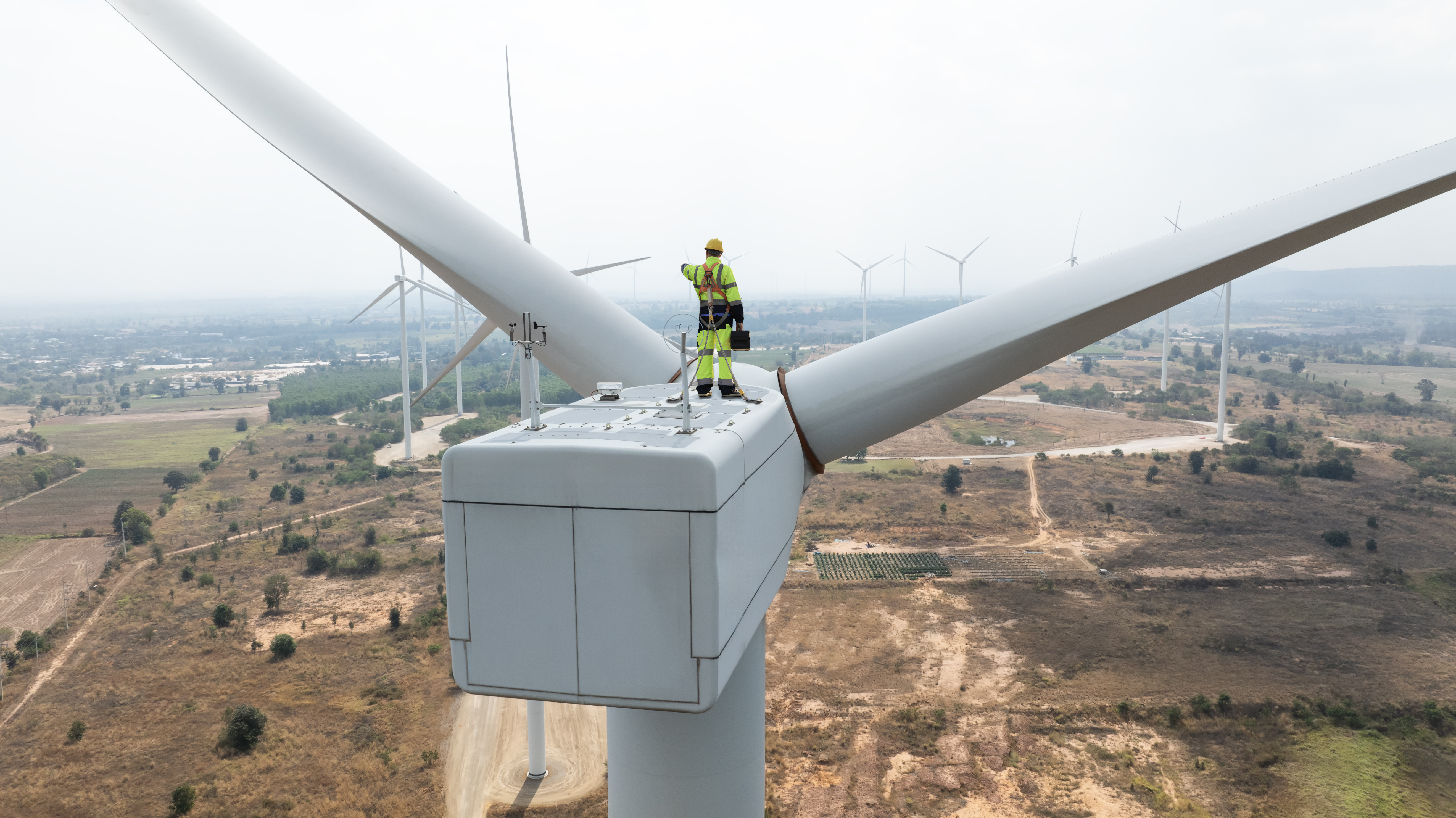 Engineer standing on wind turbine.