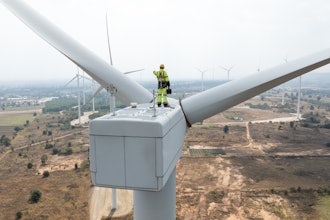 Engineer standing on wind turbine.