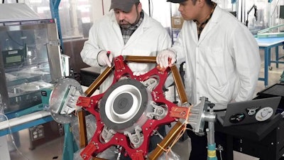 L3Harris engineers handling components of the electric thrusters.