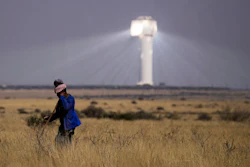 A shepherd watches livestock near Khi Solar One, a solar thermal plant that converts the sun's light energy into electricity, outside Upington, South Africa, in the Northern Cape province, Friday, Aug. 29, 2025.
