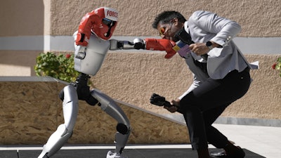 The Unitree G1 robot plays boxing with Aadeel Akhtar CEO and Founder of Psyonic at the first International Humanoid Olympiad at the Olympic Academy, in ancient Olympia, Greece, Monday, Sept. 1, 2025.